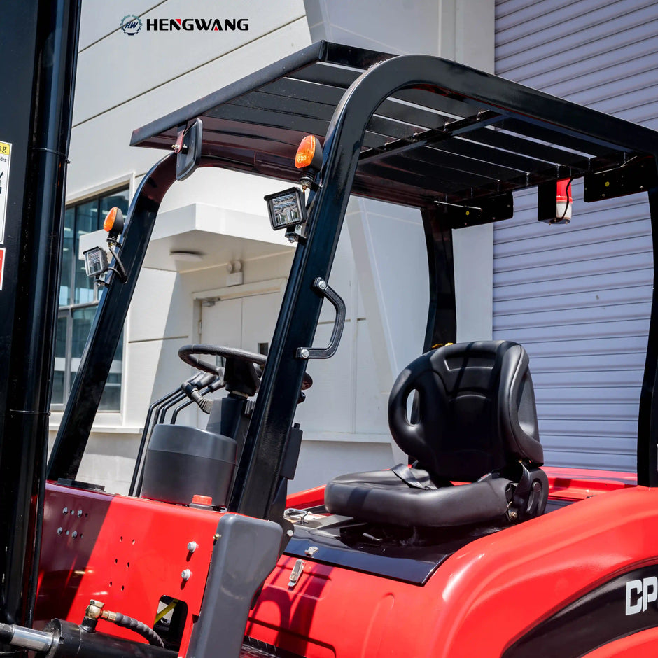 Operator compartment of a 7700 lb electric forklift showing overhead guard, adjustable seat, steering wheel, and hydraulic control levers