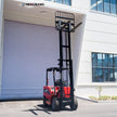 7700 lb electric forklift with fully raised mast outside a warehouse loading dock, right side view