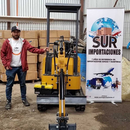 Customer standing beside yellow 1 ton mini crawler excavator inside warehouse, client delivery real photo of compact digge