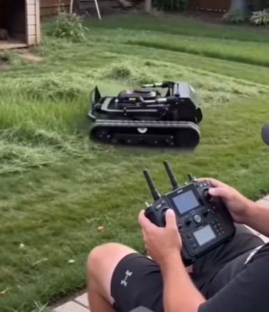 Man operating Hengwang remote crawler lawn mower with wireless radio controller, robotic slope mower trimming backyard grass